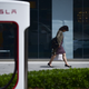 A woman walks past a Tesla car store in Beijing